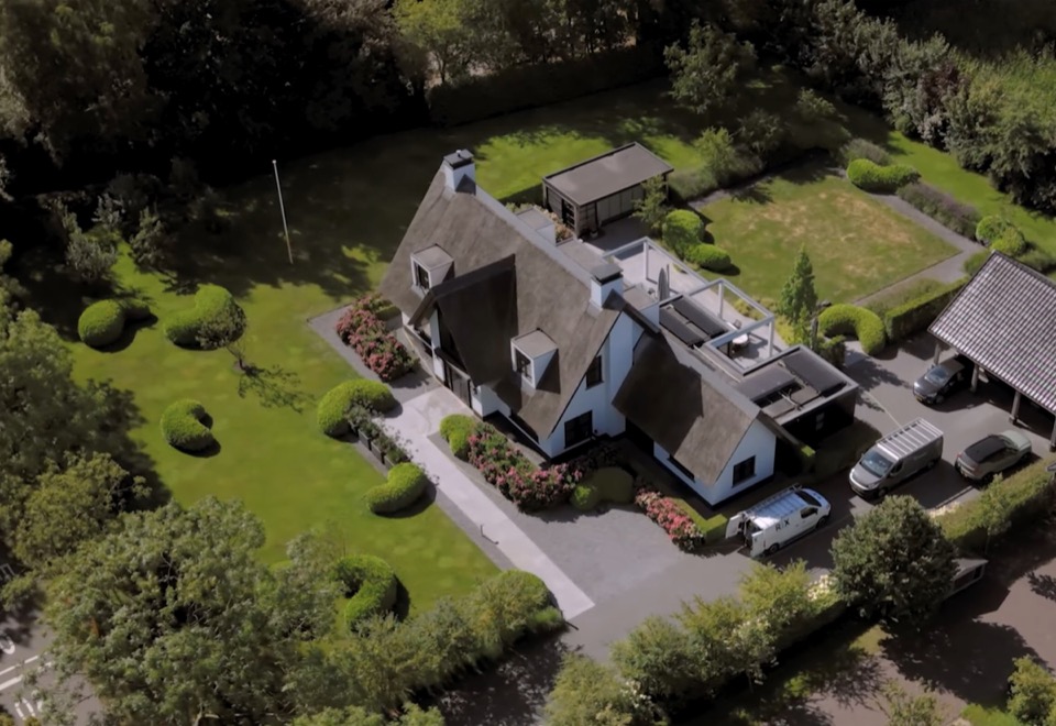 Woning met een RIX-bedrijfsbus op de oprit, vanuit de lucht gezien
