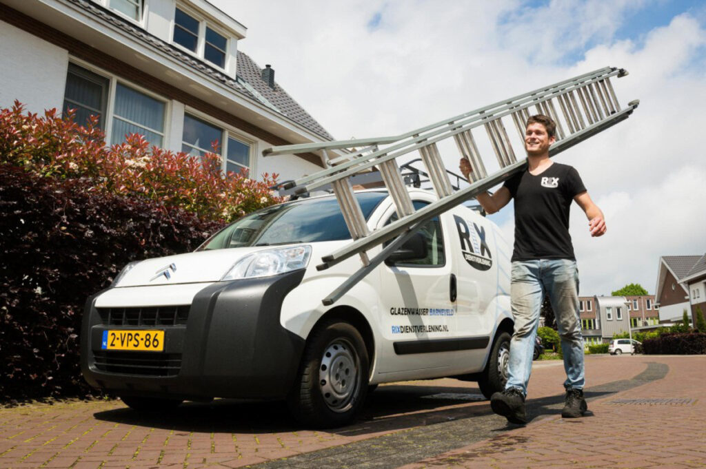 Rik van der Woerd met een ladder bij het eerste bedrijfsbusje van RIX